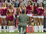 An airman purposes to an Arizona Cardinals cheerleader during the first half of an NFL football game against the Washington Redskins, Sunday, Oct. 12, 2014, in Glendale, Ariz.(AP Photo/Rick Scuteri)