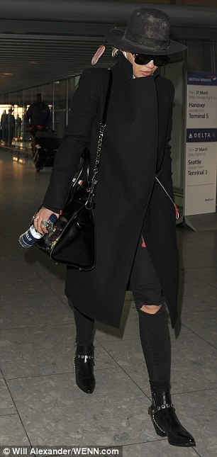 Blinged up: Keeping her accessories simple, she slung a patent black handbag over her shoulder whilst she injected a splash of colour into her ensemble with a large jade ring
