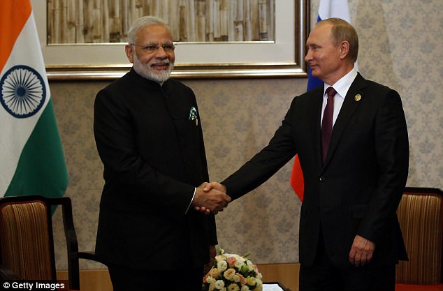President Vladimir Putin (R) shakes hands with Indian Prime Minister Narendra Modi (L) during their meeting at the BRICS summit on Monday