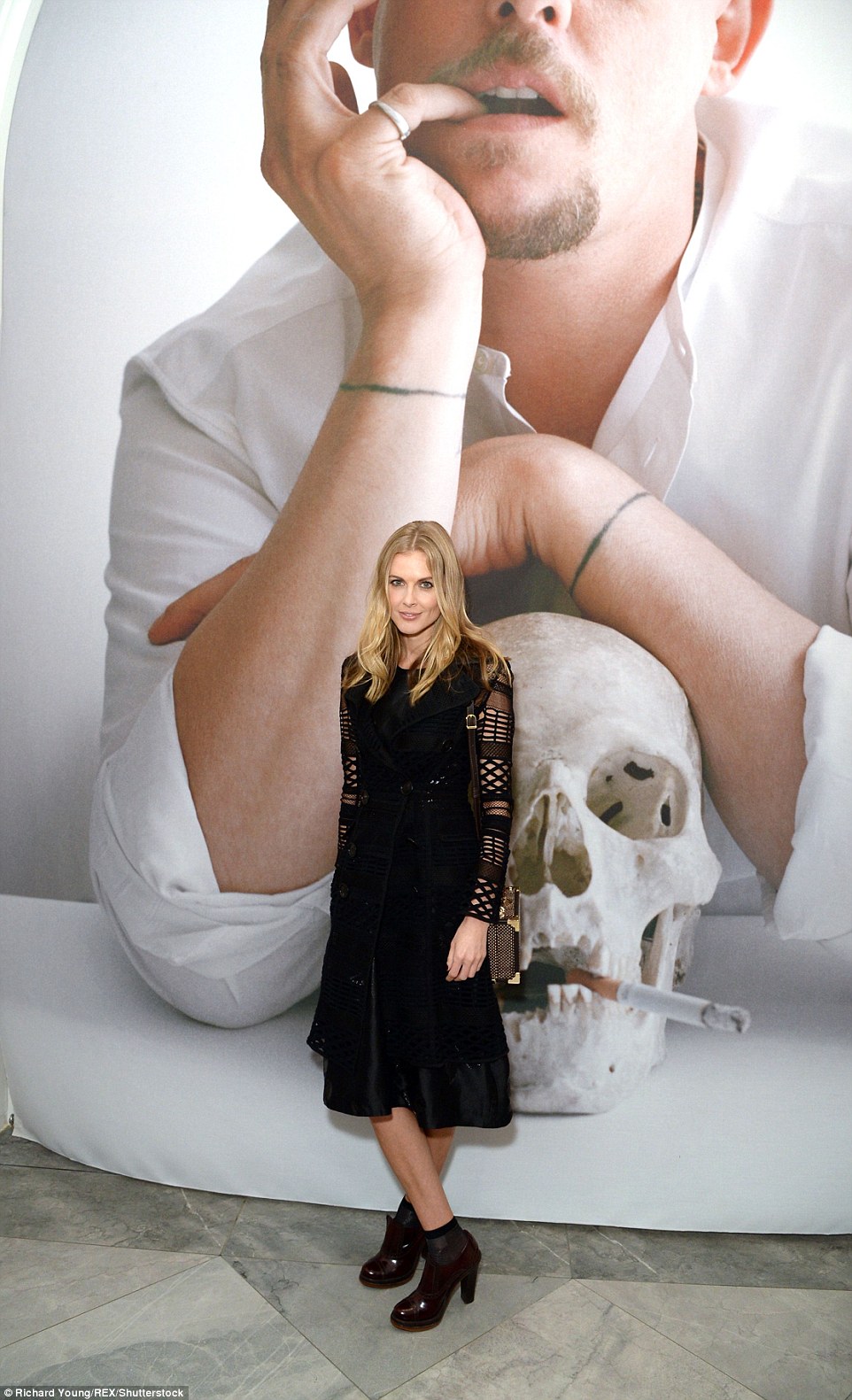 Late legend: Donna stood in front of one of the display's biggest works, a portrait of late designer Alexander McQueen, who committed suicide in 2010