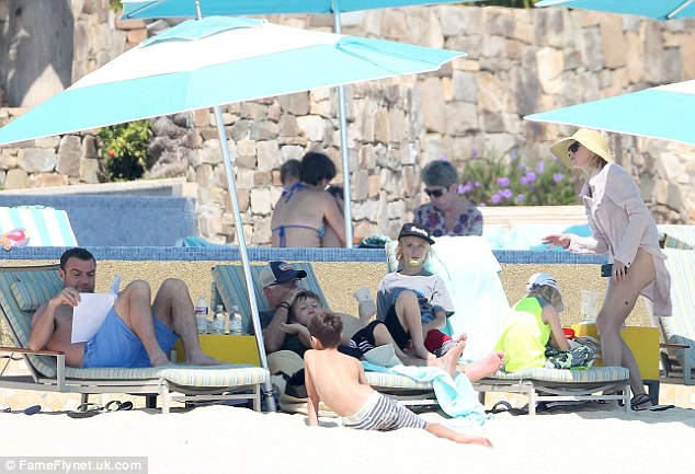 Family photo: The couple and their sons Alexander and Samuel relaxed with friends on the beach