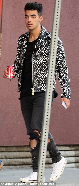 Heading in: She showed off her curvaceous backside in the body-contouring garment while the group's frontman, Joe Jonas (pictured), looked fashionable in a black leather biker jacket